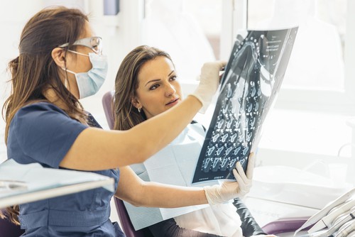 woman and dentist examine x-ray