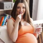 pregnant woman takes vitamin
