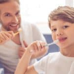 boy and father brushing teeth